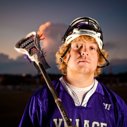 Boy's lacrosse senior portrait at sunset in the he