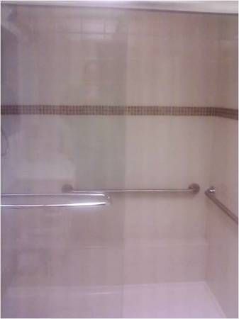 shower with glass shower doors, built in shelf and