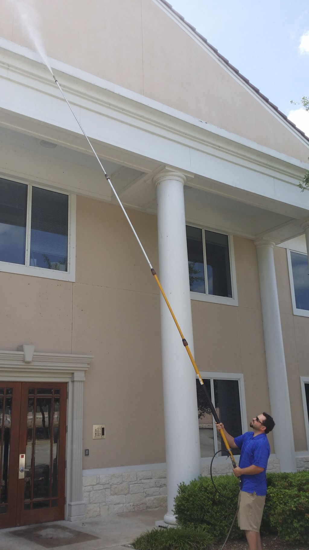 Nick Power washing 3 story eaves on a commercial b