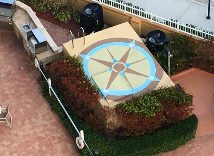 This is a mural of a compass on the top of a pool 