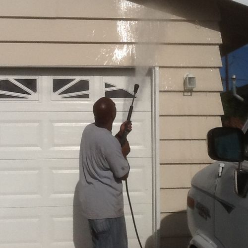 Pressure washing a single story home. Giving it th