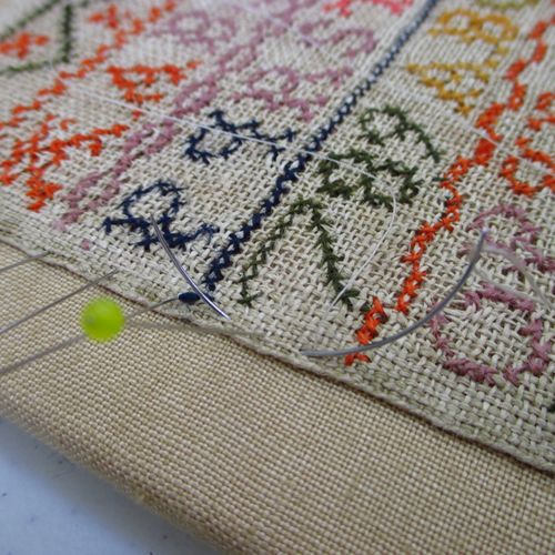 Mounting an antique sampler on linen for display p