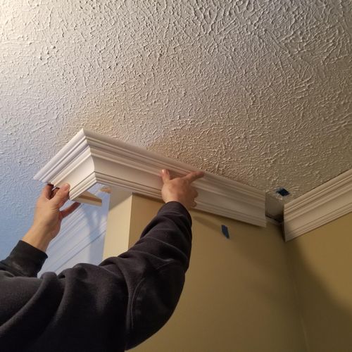 Installing the section of crown molding that he bu