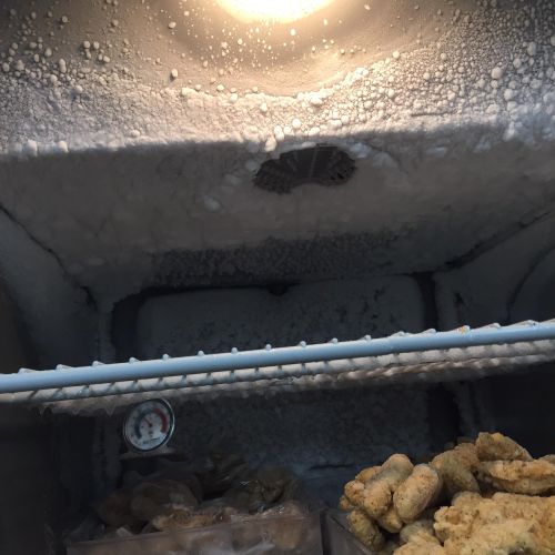 A freezer with an obvious defrost problem. Boxes a