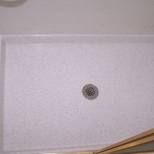 Shower pan refinished in simulated granite.