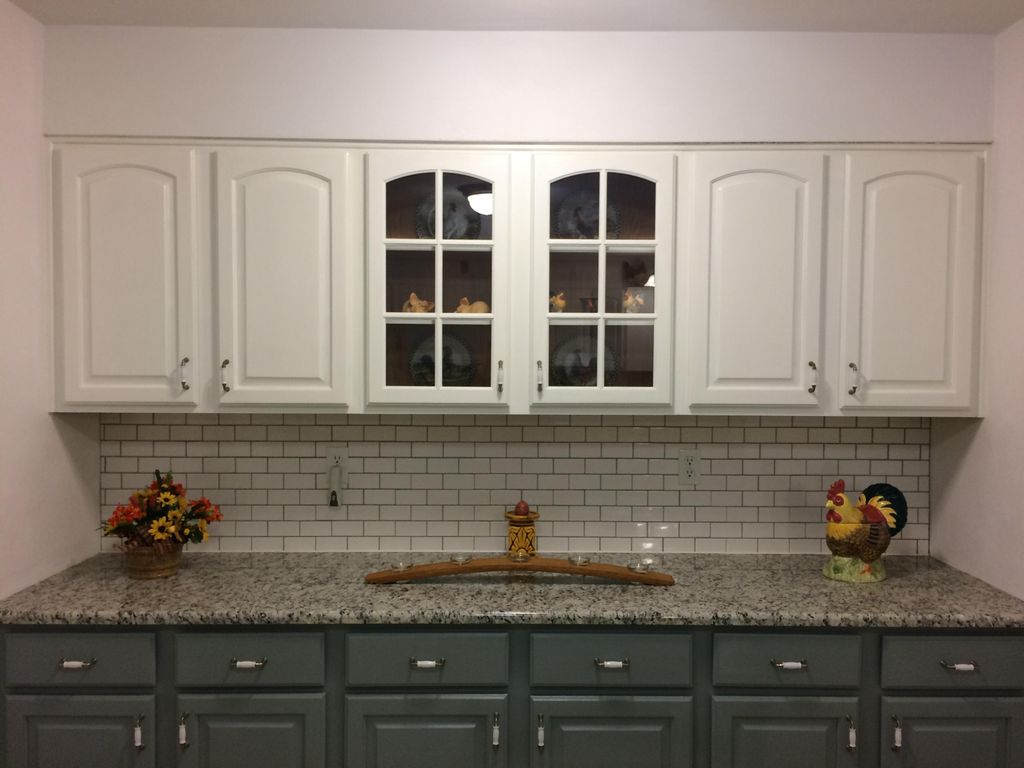 Refinished cabinetry with subway tile backsplash.