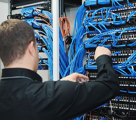 Tech working with cables patch cords in a rack