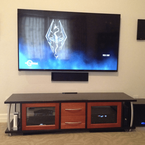 70" TV flanked by wall-mount "flat panel" speakers