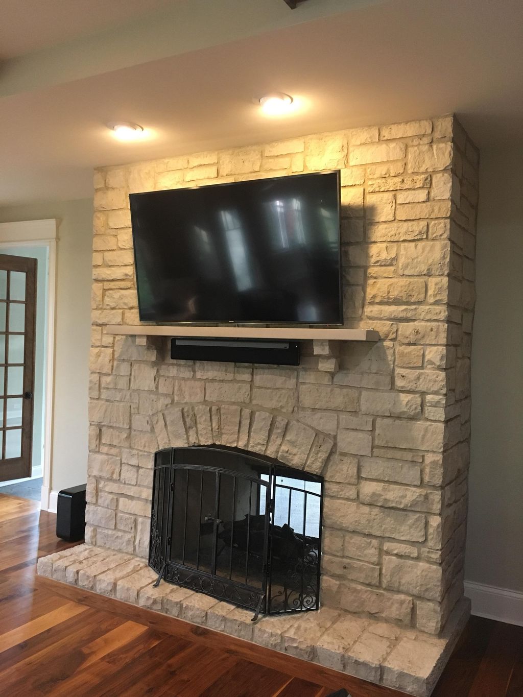 TV mounted on brick fireplace w/ Sonos Playbar