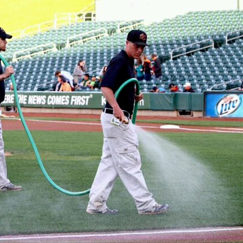 Applying pre-game water to the playing surface for