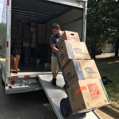 Team leader Alex loading a truck with boxes for a 