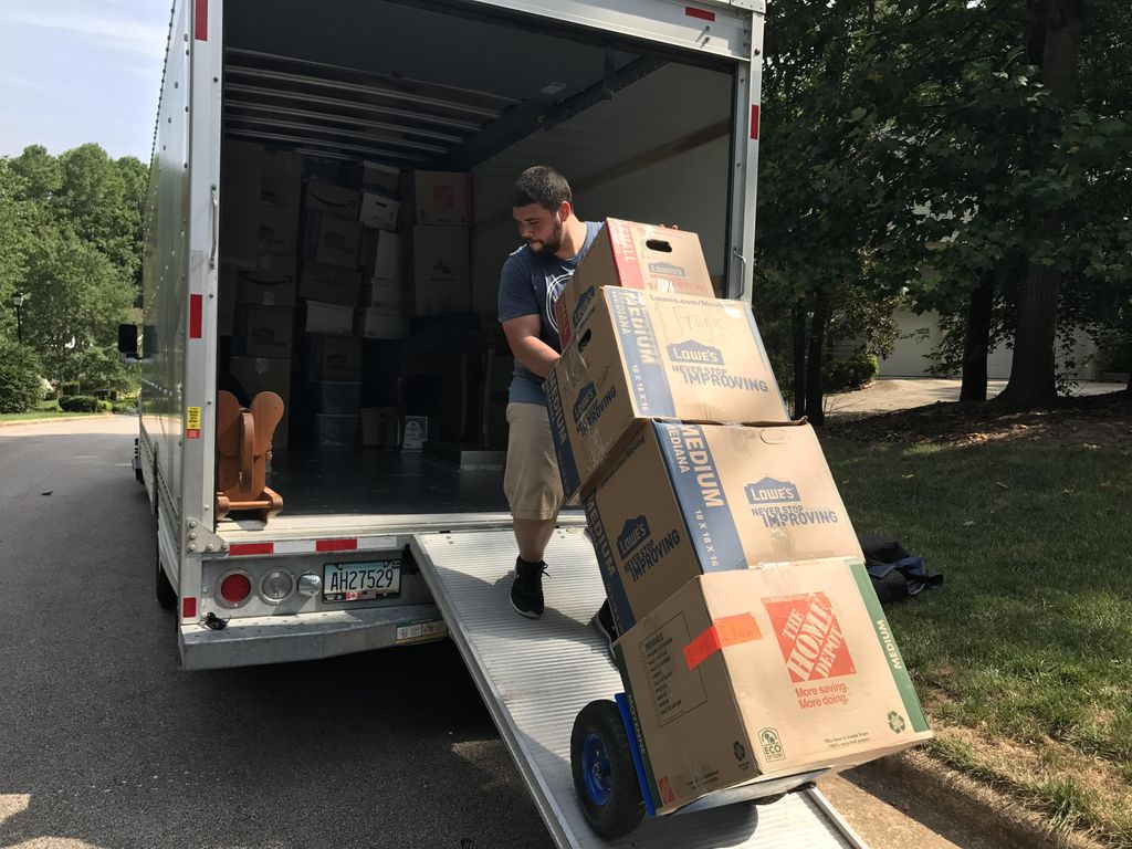 Team leader Alex loading a truck with boxes for a 