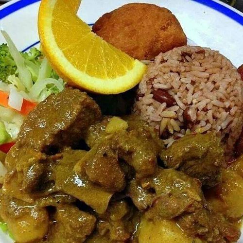 Curried goat rice and beans steamed vegetables
