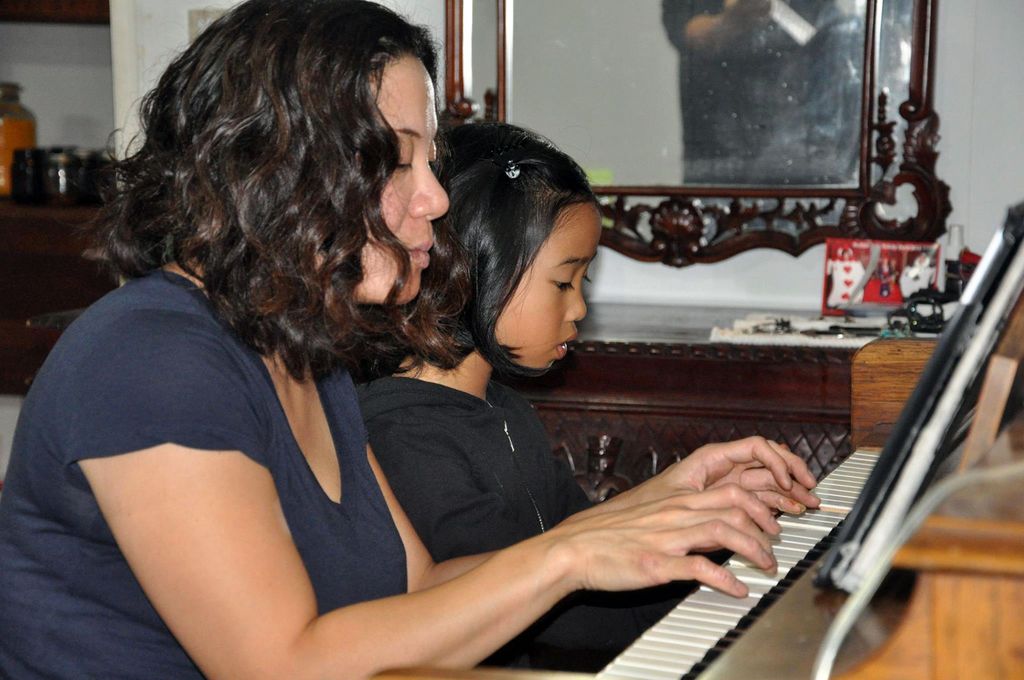 Rhoda playing piano along with a student