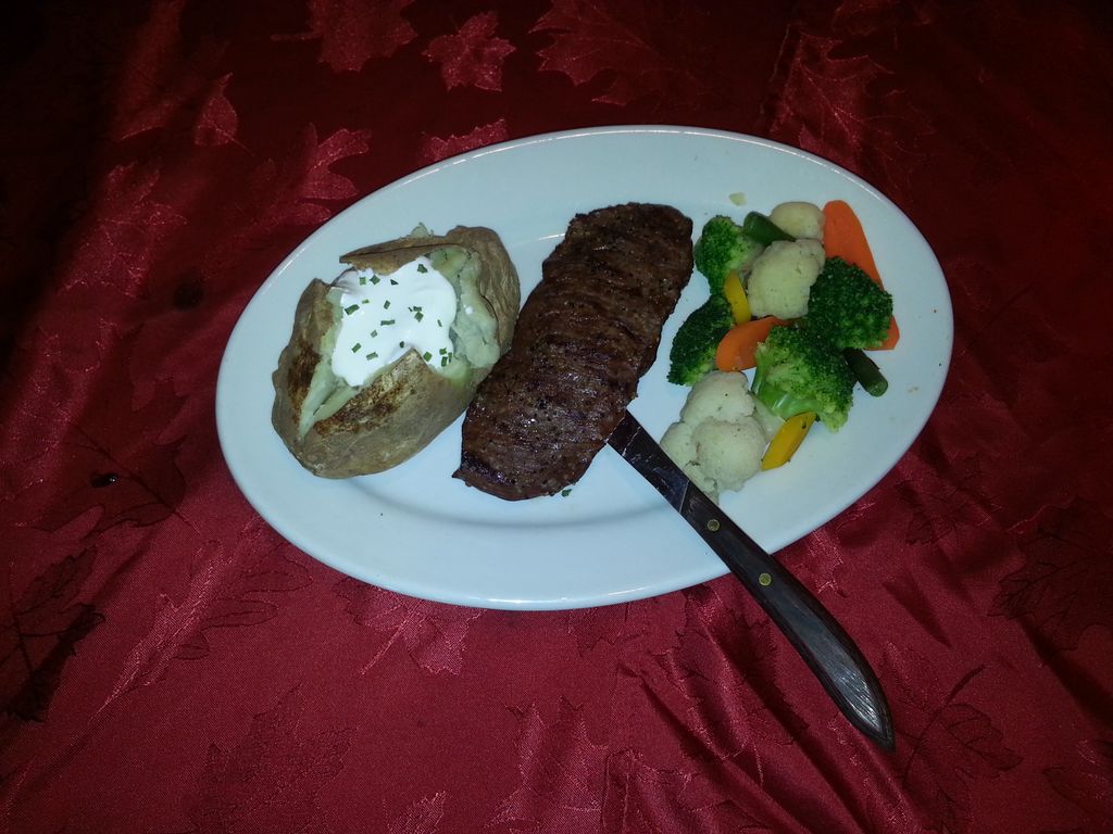 Classic grilled steak with baked potato and steame