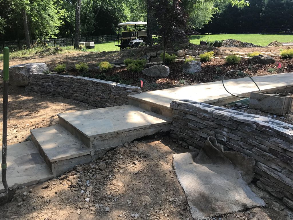 Veneer stone retaining wall, drainage and flagston