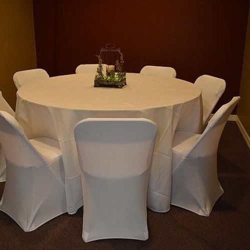 all white round tables with table cloth and chair 
