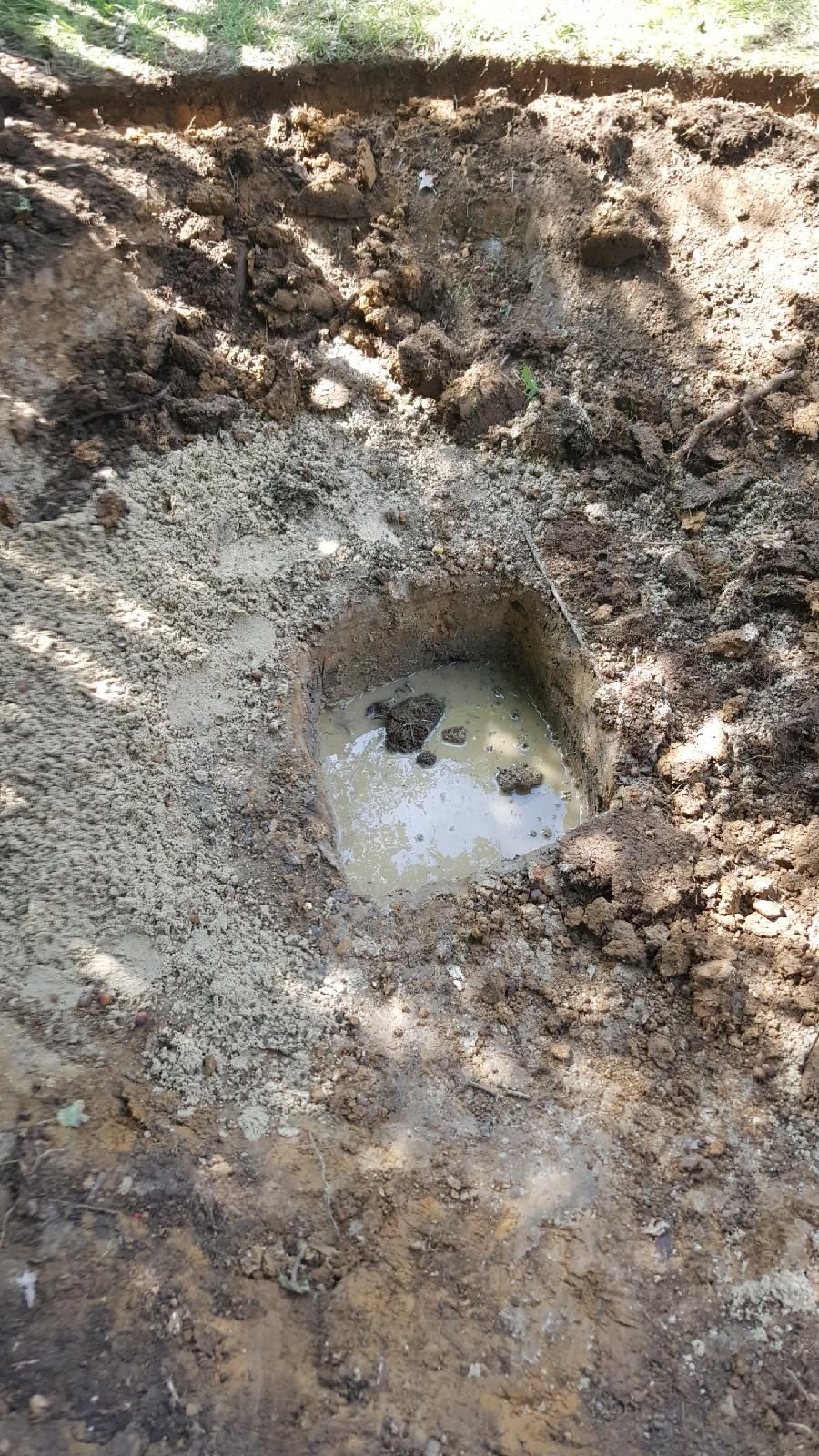 Punch hole for rain garden that was filled with sa