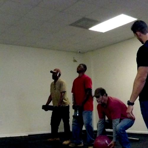 Crew at the gym learning proper lifting techniques