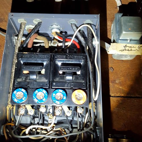 An older electric service panel with fuses reveale