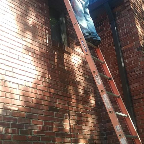 Cleaning out gutters on a two story house