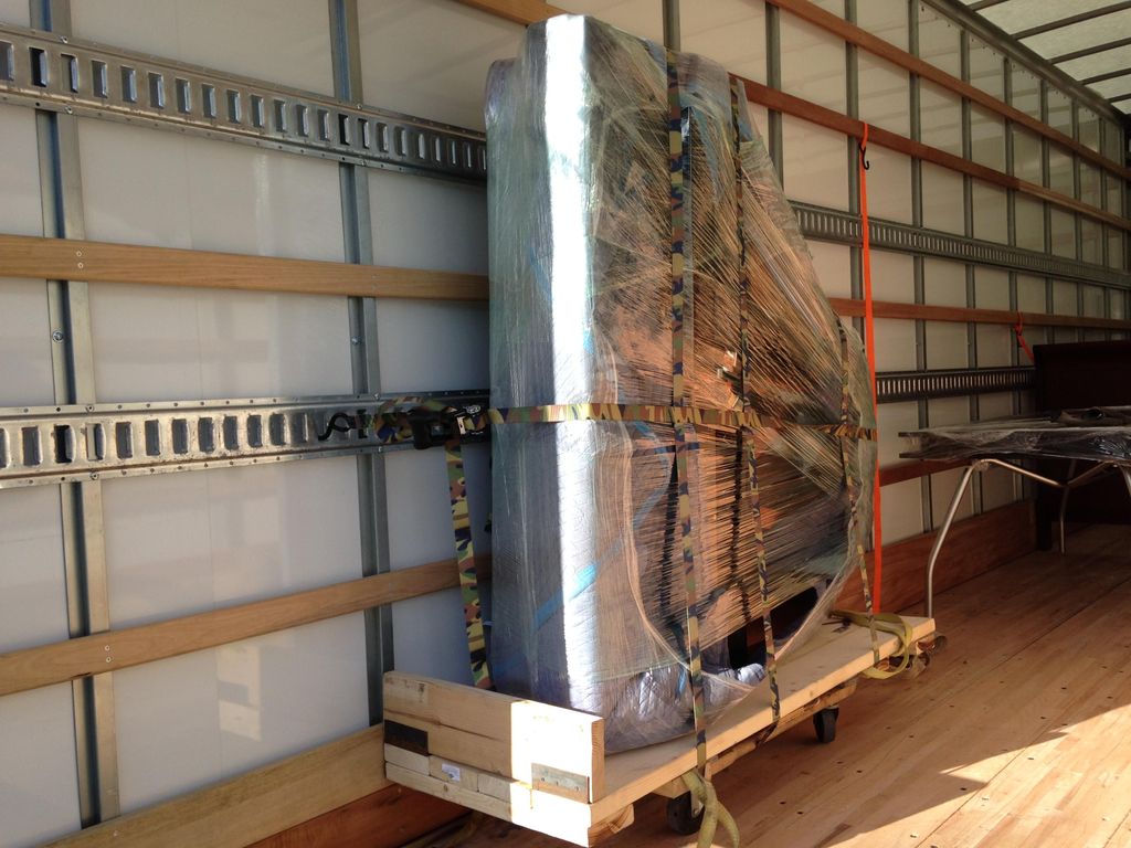 Baby grand piano safely secured in the truck.
