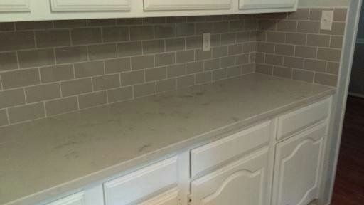 After: Gray subway tile backsplash with quartz cou