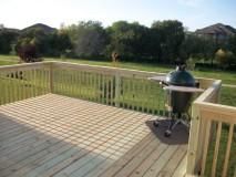 Treated wood deck with railings, spindles, and gri