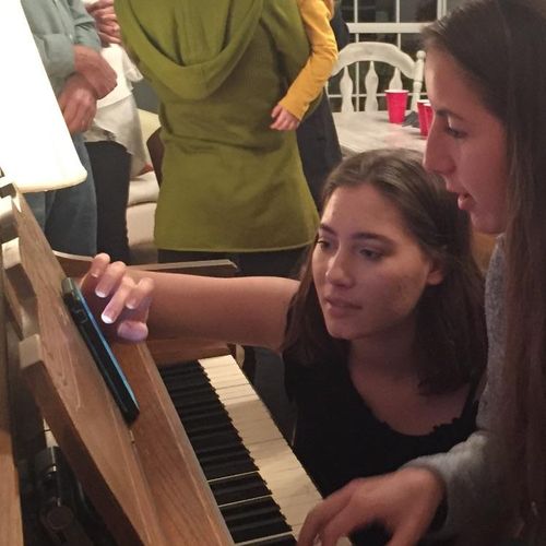 Daughter and friend having fun at the piano. Playi