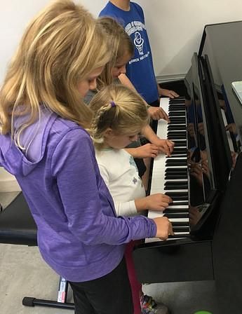 Students create an impromptu "piano band" at a gro
