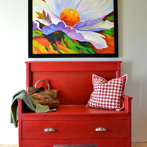 A bright bench and colorful painting greets guests