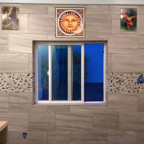 a European bathroom i tiled, murals, riverstone in