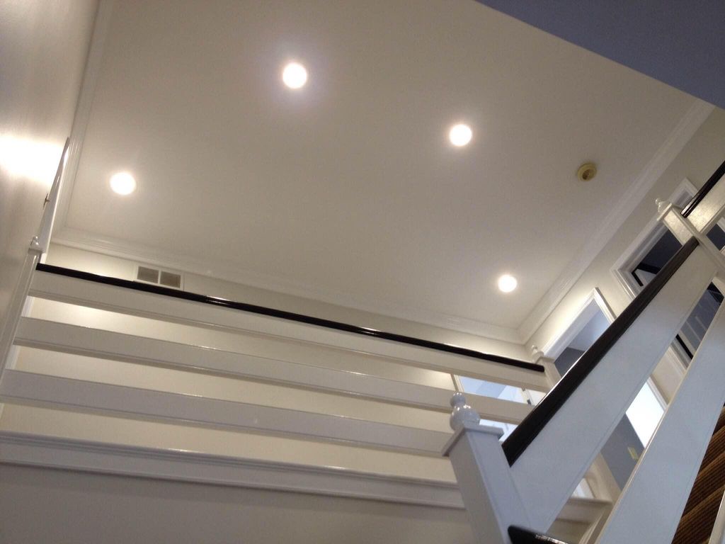 Recessed light installation at the top of a stairw