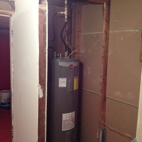 Before picture of a small water heater room.