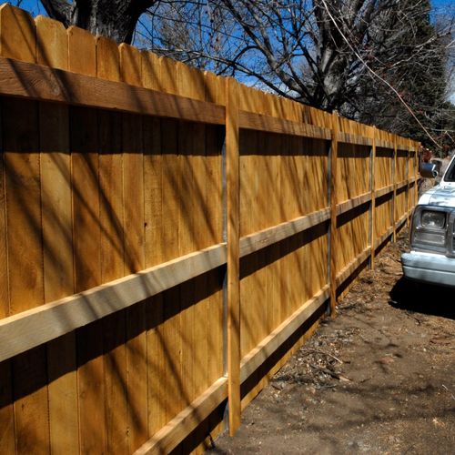 Back side cedar fence, with covered metal poles, n