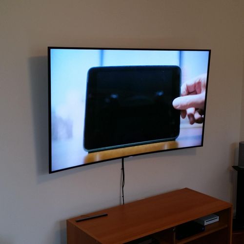 New Curve TV mounted on the wall with a tilting mo