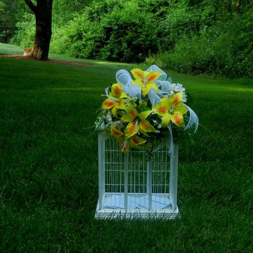An alluring white bird cage flowing with yellow fl
