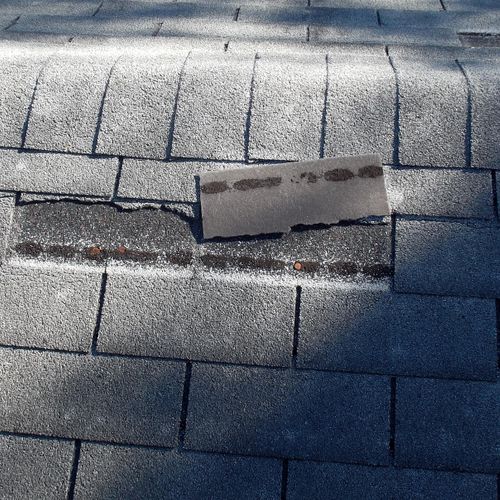 Damaged and worn roofing shingles.