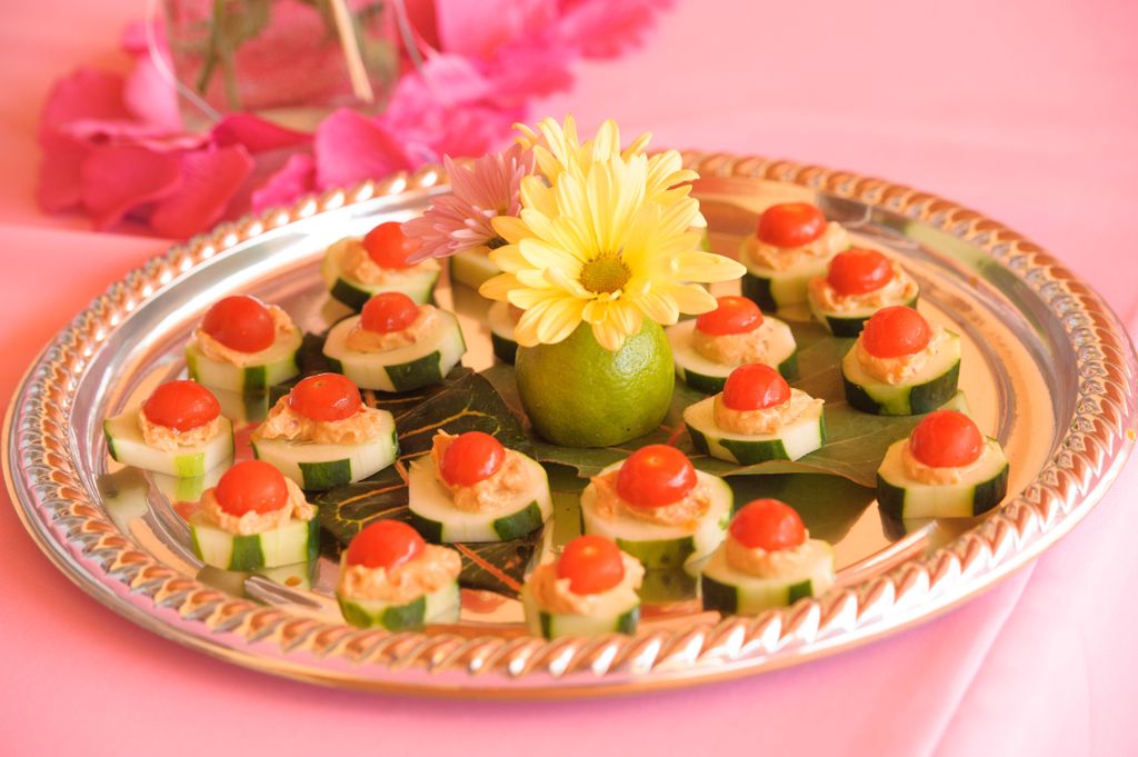 Hummus on cucumber wheel topped with a cherry toma