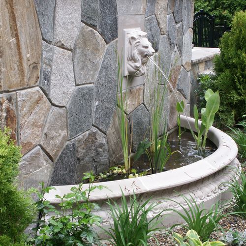 Custom limestone fountain pool and stonework greet