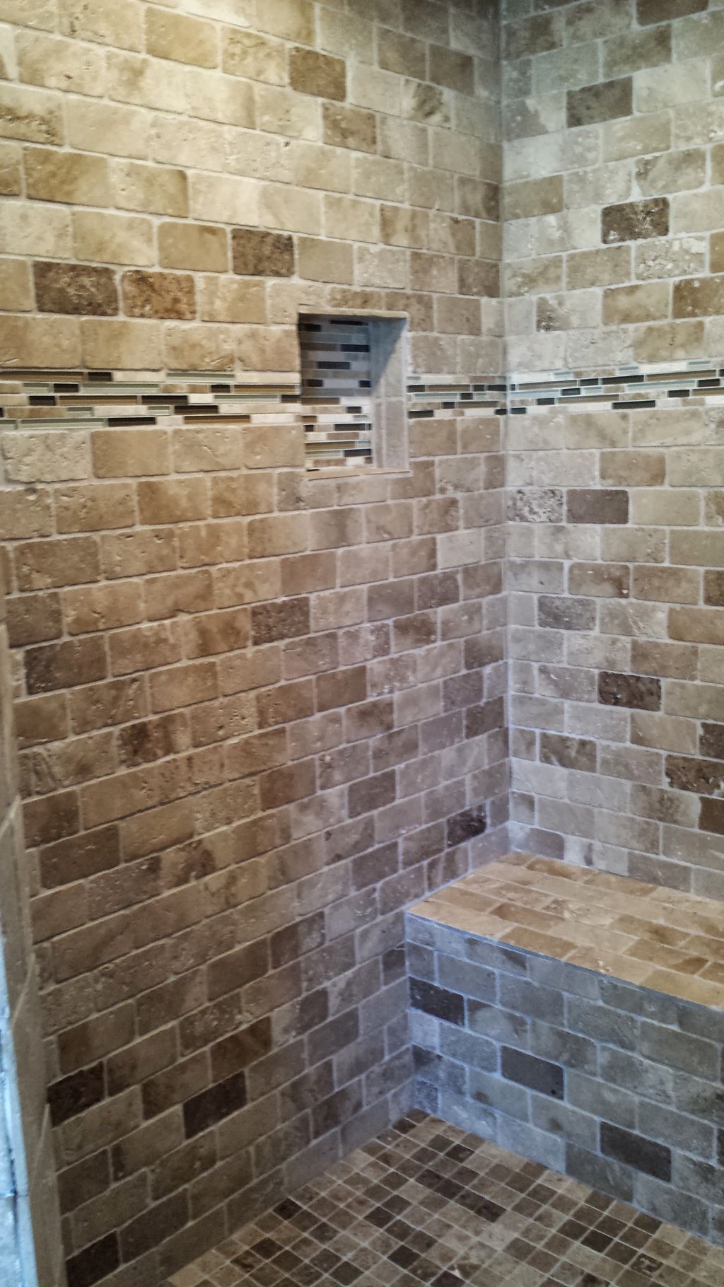 A look into the shower. tumbled marble in a brick 