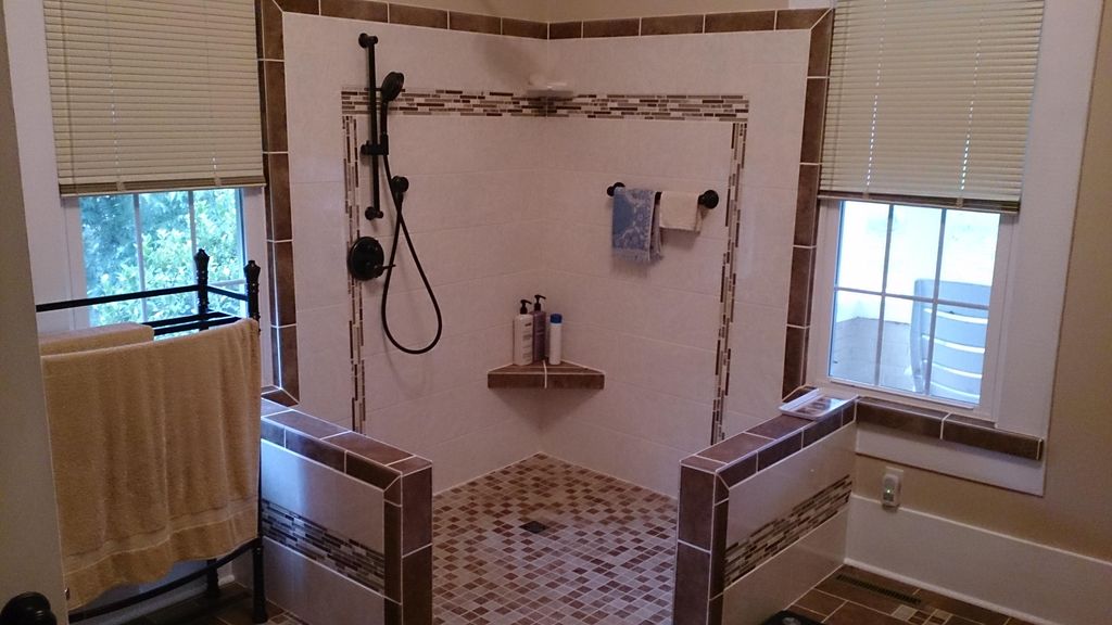 Large open custom tile shower with no curtain or d
