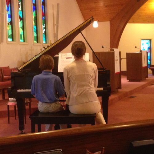 A student plays a duet with his mom.