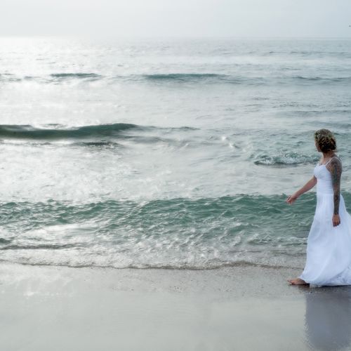 Bride walking on beach in La Jolla, CA.