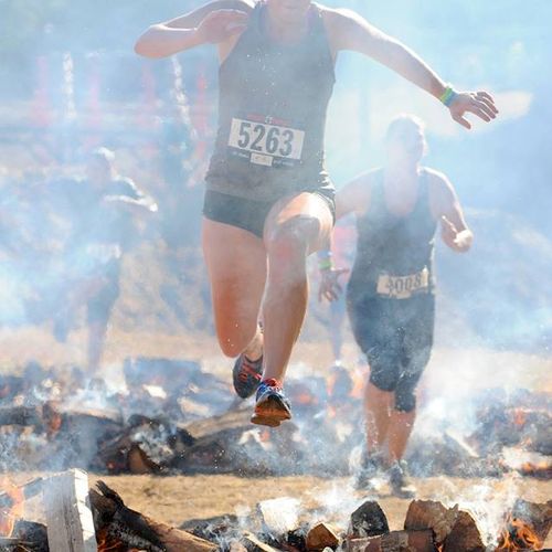 Jumping over fire in the Rugged Maniac 5k obstacle
