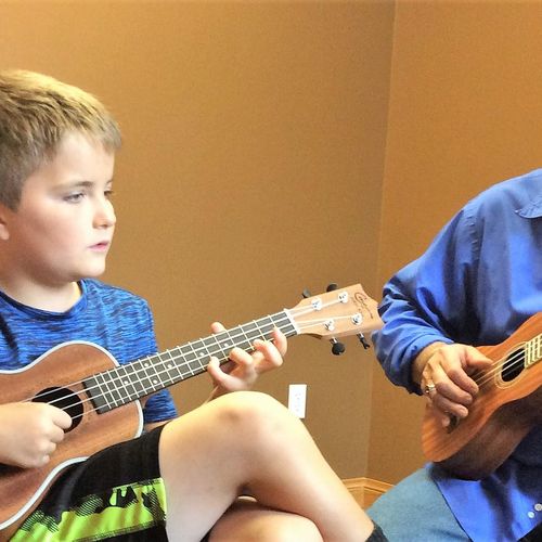 Aspiring musicians taking ukulele lessons