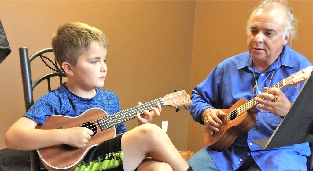 Aspiring musicians taking ukulele lessons