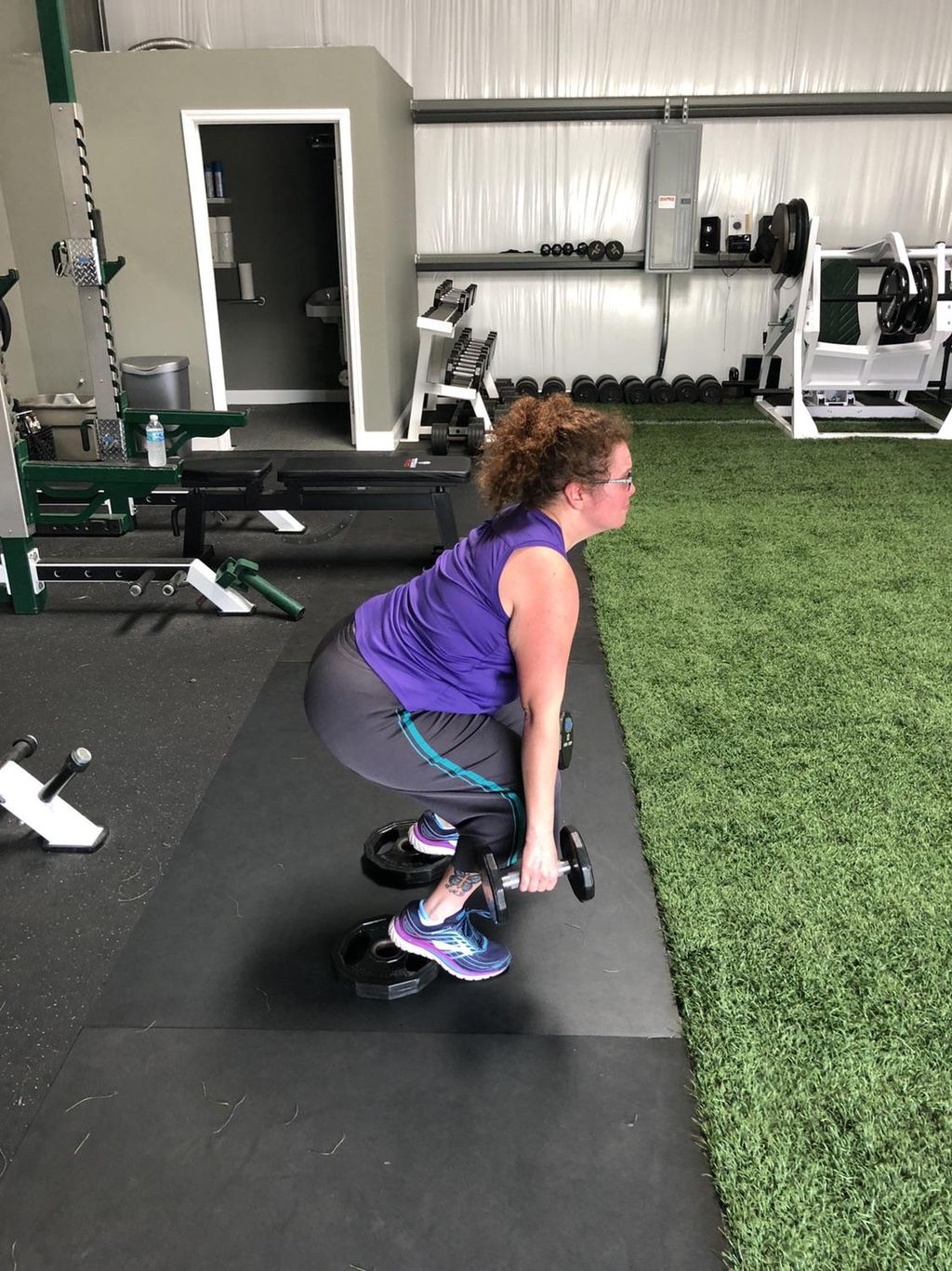 Client is performing a heel elevate squat. To isol
