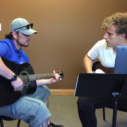 Instructor Cam encouraging guitarist