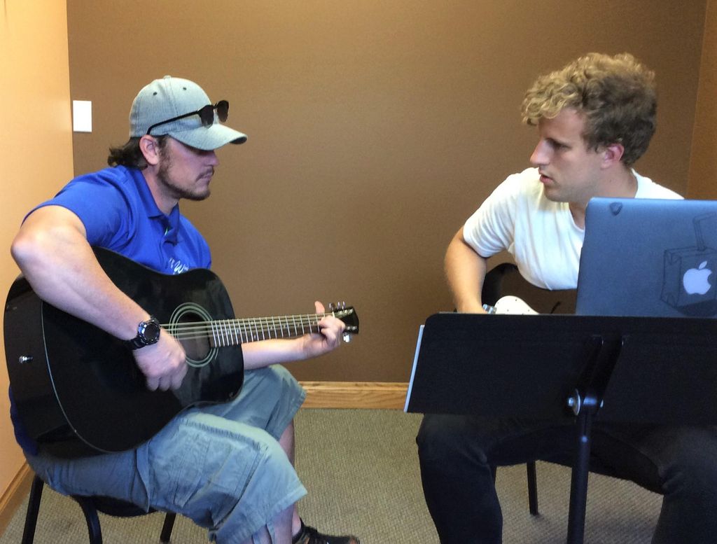 Instructor Cam encouraging guitarist
